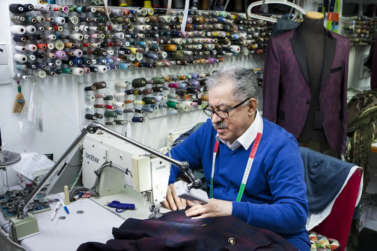 Toni an der Brother-Industrienähmaschine in seiner Änderungsschneiderei an der Gladbacher Straße 7, Köln.